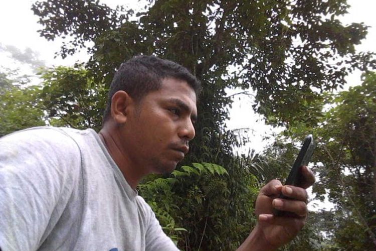 Ambrosius Adir (30), seorang wartawan berstatus kontributor sedang mencari signal untuk mengirim berita ke kantornya di kawasan hutan di antara Desa Gunung Baru dan Desa Gunung, Kecamatan Kota Komba, Kabupaten Manggarai Timur, NTT, Kamis, (9/4/2020). (KOMPAS.com/MARKUS MAKUR)