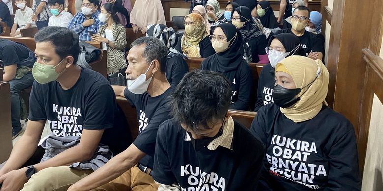 In this picture taken on February 7, 2023 parents of children, who they alleged were either killed or left sickened by tainted cough syrups, attend a hearing as part of a lawsuit at the South Jakarta district court, while wearing black shirts reading I thought it was medicine, it was poison to the court. Their class-action lawsuit targets the ministry of health, the country's food and drug agency, and eight companies implicated in selling the syrups -- which the World Health Organization said contain an unacceptable amount of diethylene glycol and ethylene glycol. 