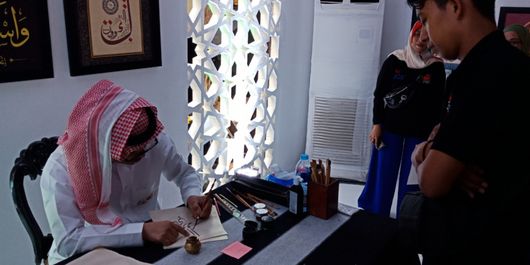 Salah satu stan kebudayaan mempraktikan pembuatan kaligrafi khas Arab Saudi gratis untuk pengunjung, di pameran kebudayaan Arab Saudi, Saudi House dalam rangka mengenalkan budaya selama Asian Games 2018, berlangsung di Resto Pulau Dua, Jakarta, Jumat (24/8/2018).