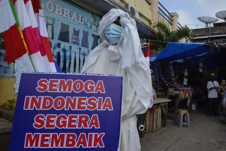 Seorang anggota Satlantas Polresta Bandar Lampung menggunakan kostum pocong saat sosialisasi bahaya COVID-19 di sejumlah Pasar tradisional di Bandar Lampung, Lampung, Jumat (6/8/2021).