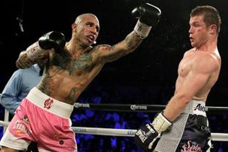 Miguel Cotto (kiri) kalah angka dari Canelo Alvarez, Sabtu (21/11/2015). 