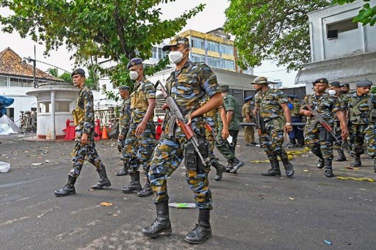 Anggota personel keamanan Sri Lanka berjalan di luar kediaman resmi Perdana Menteri Sri Lanka Mahinda Rajapaksa 'Temple Trees', sehari setelah dilanggar oleh pengunjuk rasa di Kolombo pada Selasa 10 Mei 2022. 