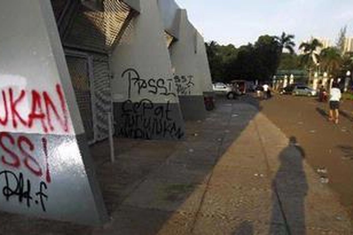 Warga lari berkeliling di samping Kantor PSSI yang dicoreti pengunjuk rasa di Kompleks Stadion Gelora Bung Karno, Senayan, Jakarta, Jumat (25/2/2011). Pengunjuk rasa menuntut Ketua Umum PSSI Nurdin Halid tidak mencalonkan diri lagi dalam kongres PSSI.