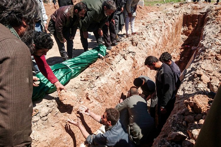 Warga menggali kuburan untuk jenazah korban dari dugaan serangan gas beracun di Khan Sheikhun, kota yang dikuasai kelompok pemberontak di Provinsi Idlib, Suriah barat laut, Rabu (5/4/2017). Sedikitnya 72 orang tewas, termasuk 20 anak-anak akibat serangan senjata kimia tersebut.