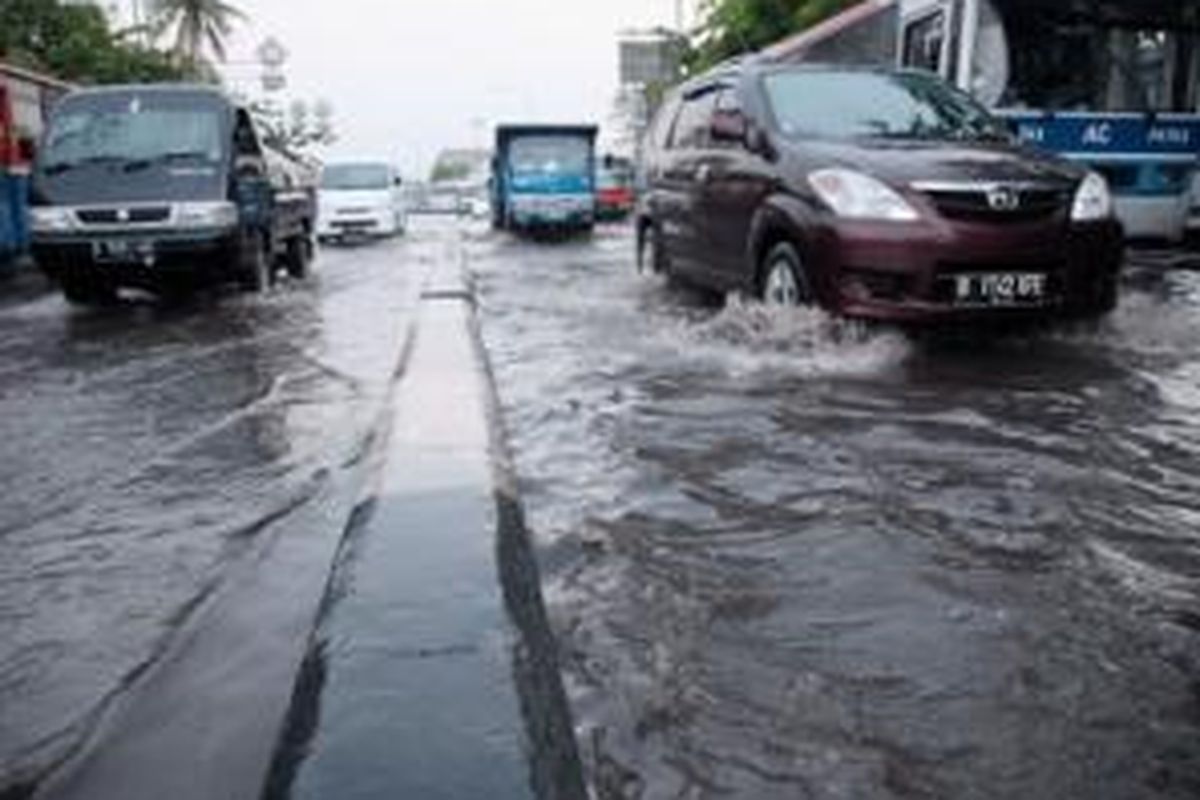 Pengguna jalan melintas di genangan air akibat hujanderas di Jalan Raya anggano, Jakarta Utara, Selasa (29/10). Buruknya kondisi saluran air di kawasan tersebut menyebabkan beberapa titik genangan di ruas Jalan RE Martadinata dan Jalan Raya Enggano usai hujan turun.