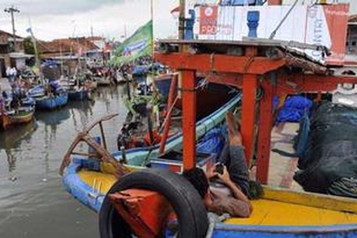 Makruf (23) bersantai di perahu yang ditambatkan di Pelabuhan Pendaratan Pantai Morodemak, Demak, Jawa Tengah, Senin (12/12/2011). Sudah sekitar 10 hari Makruf dan nelayan di tempat ini tidak melaut. Selain faktor musim angin barat yang membuat gelombang laut tinggi, nelayan di daerah ini juga memiliki keyakinan bahwa saat purnama nelayan tidak baik untuk melaut karena tangkapan sedikit.