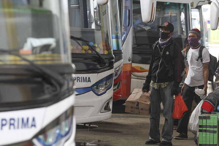 Sejumlah calon penumpang bersiap naik bus di area Terminal Jatijajar, Depok, Jawa Barat, Kamis (23/4/2020). Pemerintah memutuskan kebijakan larangan mudik Lebaran 2020 bagi masyarakat mulai berlaku Jumat (24/4) guna memutus mata rantai penyebaran COVID-19.