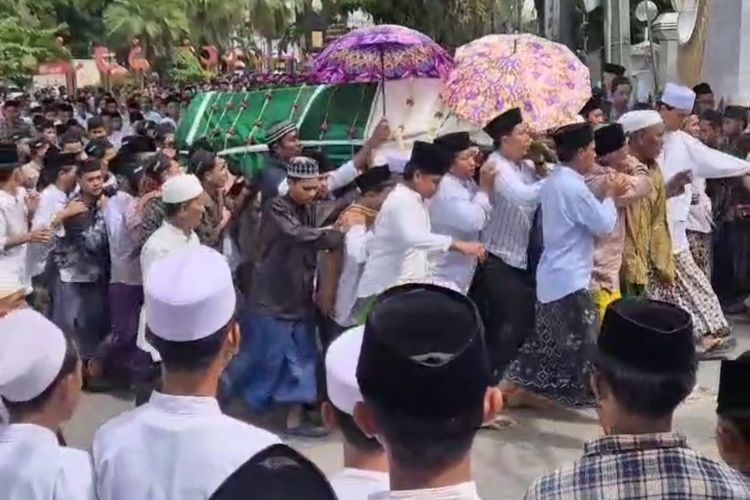 Ribuan santri dan masyarakat Bangkalan bergantian menandu jenazah KH Ahmad Faruq Muhtarom, Bangkalan, Selasa (29/7/2025). 