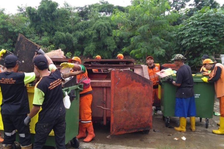 Petugas tampak mengangkut sampah pascabanjir di wilayah Kelurahan Kramat Jati, Jakarta Timur, Minggu (1/3/2020).