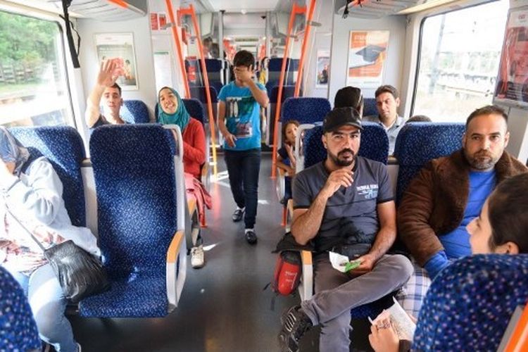 Migran duduk di kereta menuju Graz di stasiun kereta api di Spielfeld, Austria dekat perbatasan Slowakia-Austria pada 20 September 2015. Pada Senin (28/11/2022), layanan kereta api di Australia berhenti total karena karyawan mogok massal.