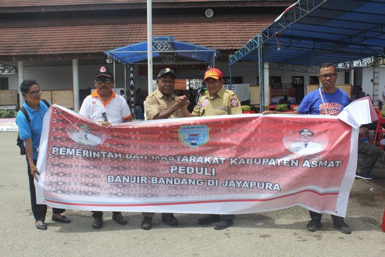 Kepala Dinas Sosial Asmat Amir Mahmud menyerahkan bantuan korban banjir bandang kepada Bupati Jayapura Mathias Awaitouw, di Posko Induk Gunung Merah, Kantor Bupati Jayapura, Minggu (31/3/2019)