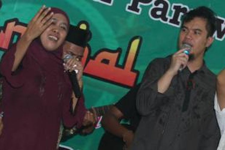 Calon Gubernur Jawa Timur Khofifah Indar Parawansa bernyanyi bersama pentolan grup band Dewa dalam rangkaian kampanyenya di Jombang, Senin (19/8/2013).