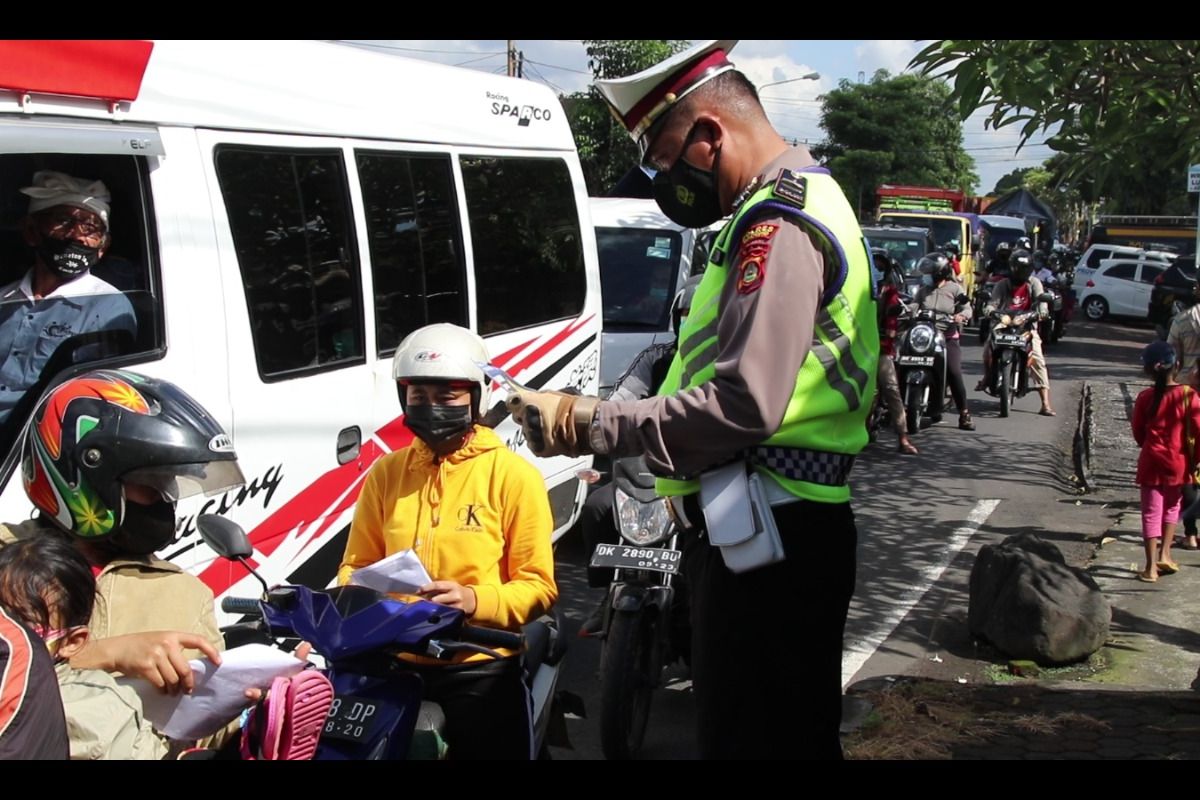 Petugas kepolisian melakukan pengecekan dukumen perjalanan di Mengwi, Badung, Bali