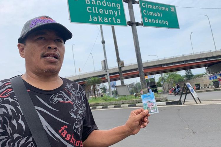 Mamat menjajakan kartu e-Toll di pintu masuk Gerbang Tol Padalarang, Kabupaten Bandung Barat, Sabtu (30/4/2022).