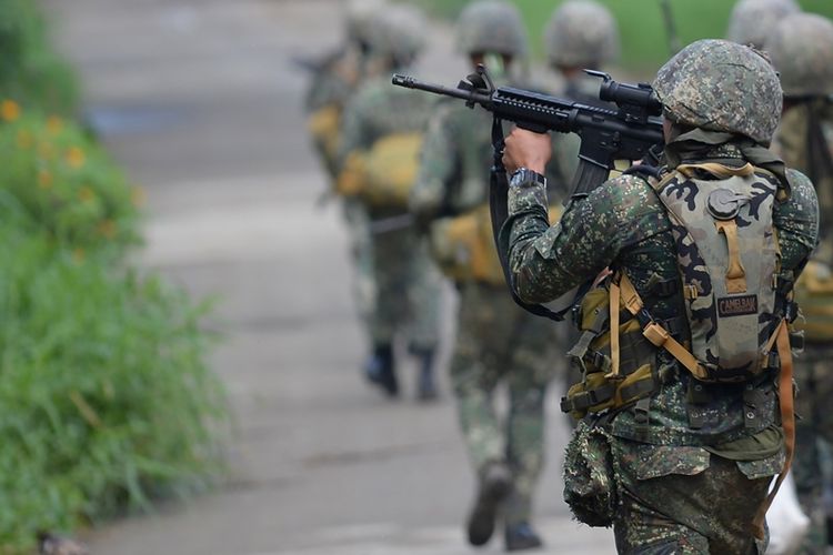 Seorang personel marinir Filipina membidik senapan serbunya saat berpatroli di kota Marawi, Mindanao.