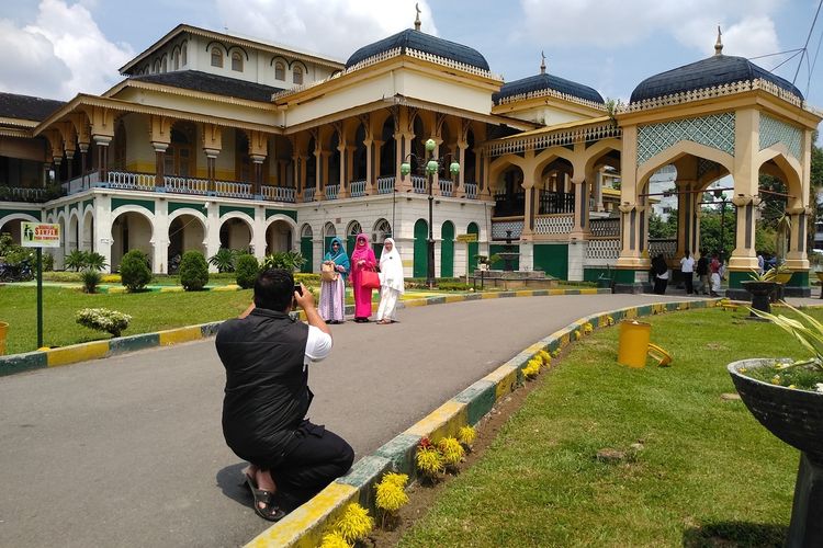 Pengunjung dari pesantren on the road yang baru datang di Istana Maimun berfoto di halaman Istana Maimun yang sejak hari ini hingga 14 hari ke depan ditutup untuk mencegah penyebaran covid-19.
