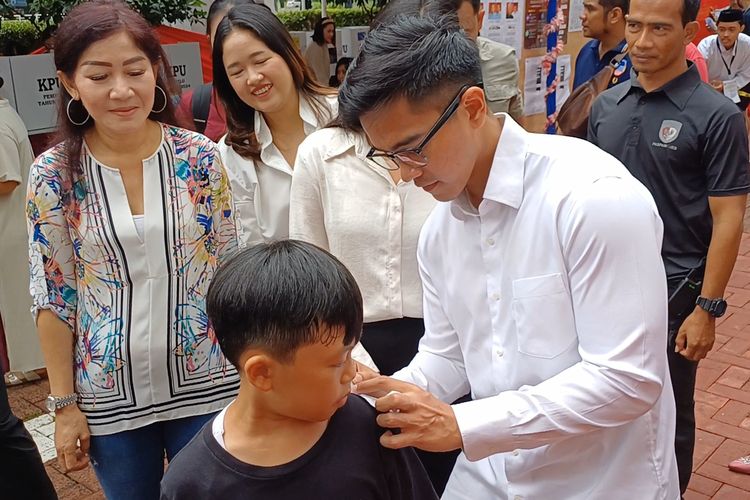 Momen Kaesang Pangarep saat membubuhkan tanda tangannya di secarik kertas yang diminta seorang anak usai dirinya mencoblos di TPS 063 Tower 10 Apartemen Taman Rasuna, Setiabudi, Jakarta Selatan, Rabu (14/2/2024).
