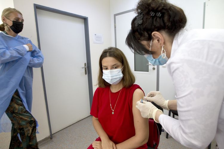 Petugas medis menyuntikkan vaksin Pfizer ke seorang wanita di Tbilisi, Georgia, pada Selasa (27/7/2021). Amerika Serikat menyumbangkan 500.000 dosis vaksin Pfizer ke Georgia yang tiba di ibu kota Tbilisi hari Sabtu (18/7/2021).