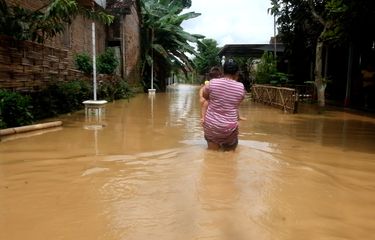 Warga desa Salamrejo Kecamatan Karangan Trenggalek Jawa Timur, melintas di kawasan wisata yang terendam banjir, Sabtu (08/10/2022).