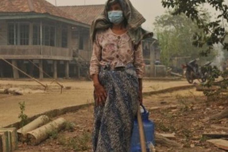 Warga berada di pekarangan rumahnya yang diselimuti kabut asap karhutla, Puding, Kumpeh Ilir, Muarojambi, Jambi, Minggu (22/9/2019). 