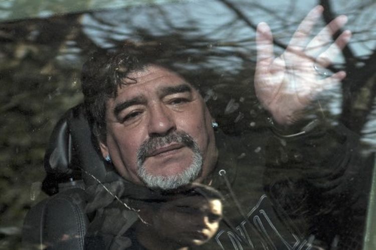 Dalam file foto ini diambil pada 26 Juni 2015 Mantan bintang sepak bola Argentina Diego Armando Maradona melambaikan tangan kepada para pendukungnya saat ia meninggalkan pemakaman ayahnya Don Diego, di Bella Vista, pinggiran Buenos Aires. 