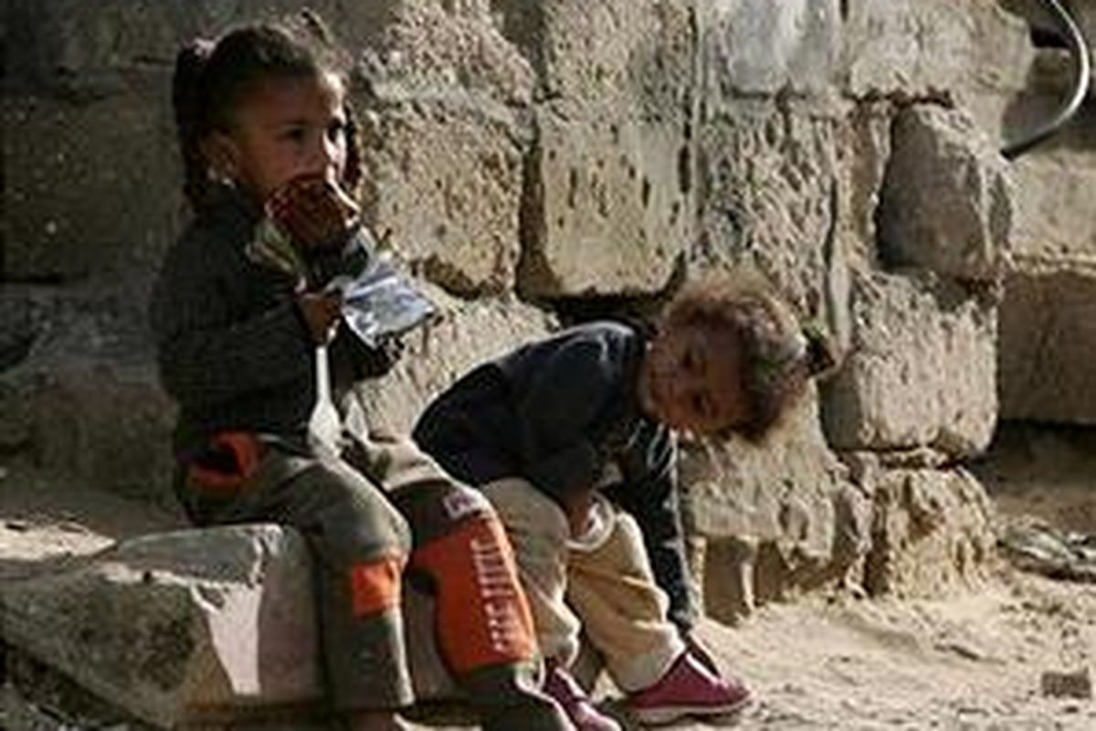 Dua bocah duduk di depan rumahnya di kawasan Al-Moghraqa, Jalur Gaza.