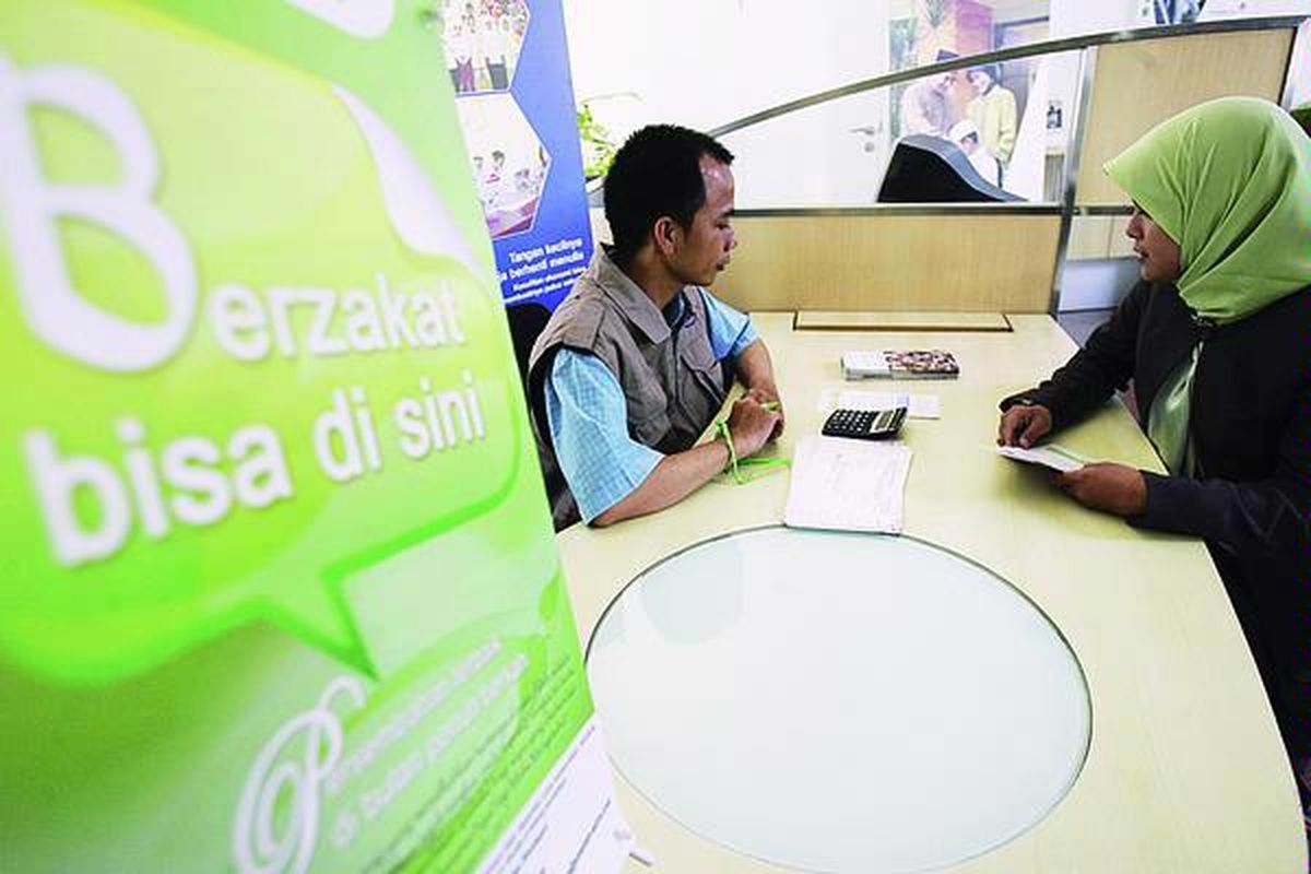 Nasabah mencari informasi kepada petugas di gerai pembayaran zakat di Bank Permata Syariah.