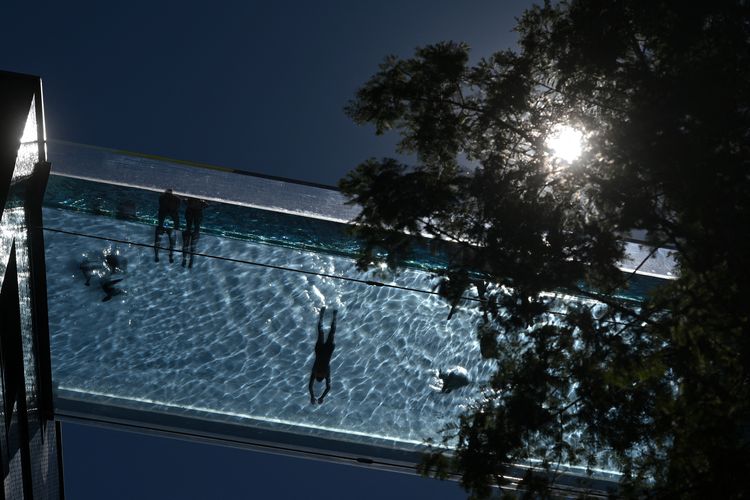 Orang-orang berenang di Sky Pool - sebuah kolam renang berbahan akrilik transparan yang dibangun di antara dua blok apartemen di London pada 1 Juni, 2021. 