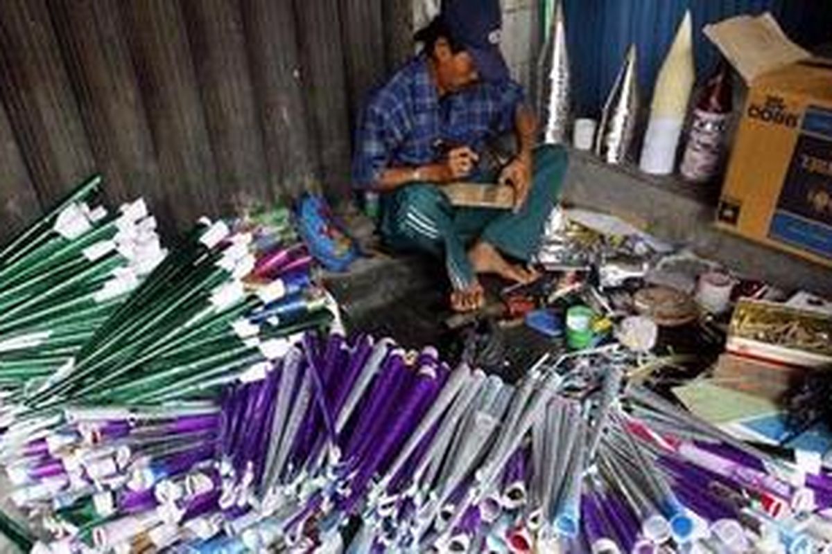 Dadang (48) tengah menyelesaikan hiasan terompet di Kawasan Pasar Glodok, Jakarta Barat, Selasa (21/12/2010). Bersama puluhan warga Bekasi lainnya, ia mencoba peruntungan malam Tahun Baru dengan menjual terompet. Setiap terompet ia jual antara Rp 5.000 hingga Rp 15.000. 