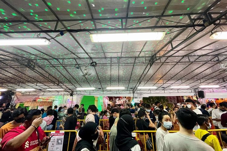 Pengunjung mengantri panjang untuk memasuki lokasi Bazaar Ramadhan 2022 Singapura di Wisma Geylang Serai, Jumat malam (15/04/2022). Bazaar Ramadhan Singapura kembali digelar setelah dua tahun ditiadakan karena penyebaran pandemi Covid-19