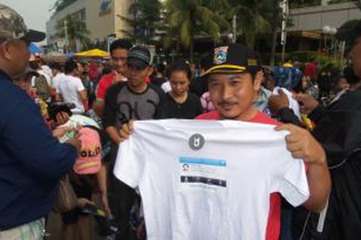 Salah satu pembeli kaos bertema Wakil Ketua DPRD Abraham Lunggana alias Lulung, yang dijual di kawasan Bundaran HI, Jakarta, Minggu (15/3/2015)