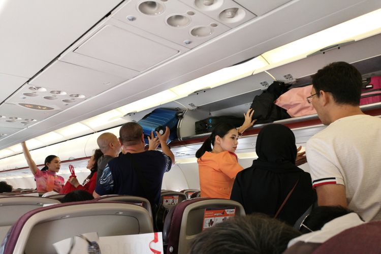 Ilustrasi kabin pesawat dengan kompartemen penyimpanan bagasi kabin.