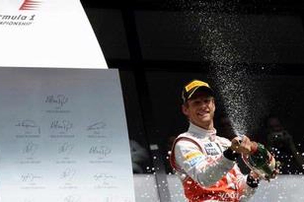 Pebalap McLaren, Jenson Button, merayakan kesuksesannya menjuarai GP Belgia, Minggu (2/9/2012).