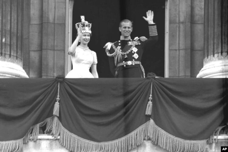 Ratu Inggris Elizabeth II dan Pangeran Philip, Duke of Edinburgh, melambaikan tangan mereka kepada para pendukungnya dari balkon di Istana Buckingham, setelah penobatannya di Westminster Abbey. London, Juni. 2, 1953.