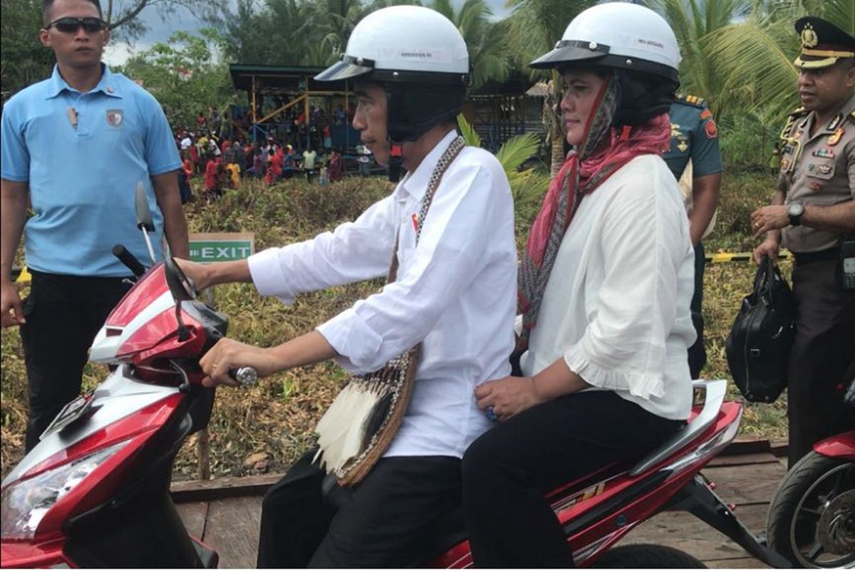 Presiden Joko Widodo memboncengi Ibu Negara Iriana saat blusukan di Kota Agats, Kabupaten Asmat, Provinsi Papua, Kamis (12/4/2018).