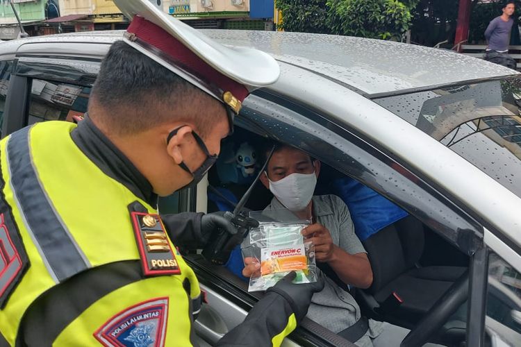 Kasat Lantas Polresta Bandar Lampung, AKP Rafly Yusuf memberikan multivitamin kepada pengendara yang terjaring razia Operasi Lilin Krakatau 2020.