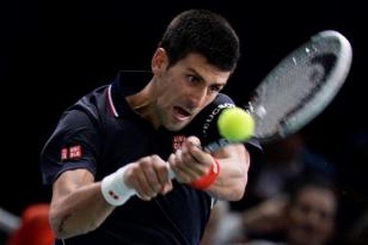 Petenis Serbia, Novak Djokovic, mengembalikan bola ke arah petenis Inggris, Andy Murry, pada laga perempat final Paris Masters, Jumat (31/10/2014). Djokovic menang 7-5, 6-2.