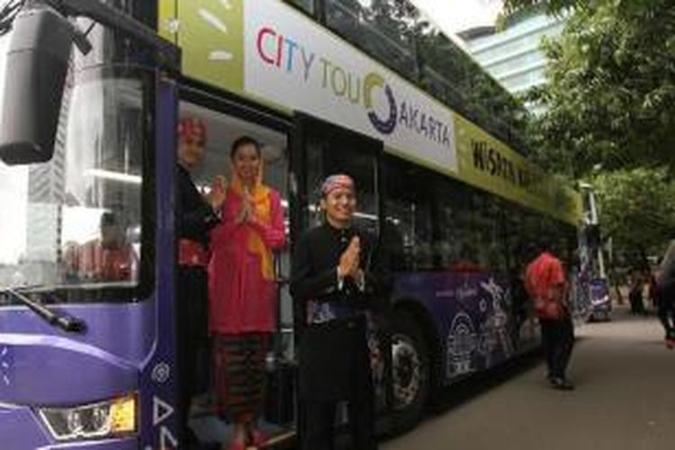 Abang None Jakarta berpose di bus tingkat wisata saat diperkenalkan kepada masyarakat di sekitar Bundaran HI, Jakarta Pusat, Kamis (16/1/2014). Pemprov DKI Jakarta mendatangkan lima bus tingkat dari China untuk meningkatkan pariwisata, yang akan mulai dioperasikan awal Februari.