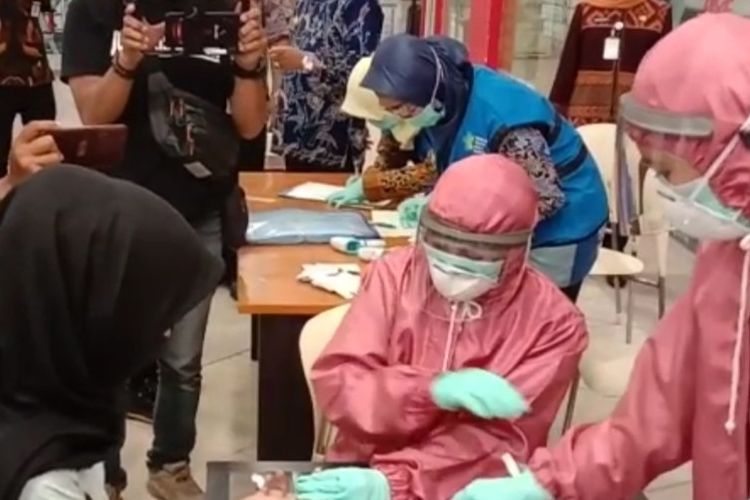 Petugas medis berpakaian lengkap melakukan rapid test kepada salah satu pengunjung pusat perbelanjaan di Kota Tegal, Jawa Tengah, Selasa (19/5/2020)