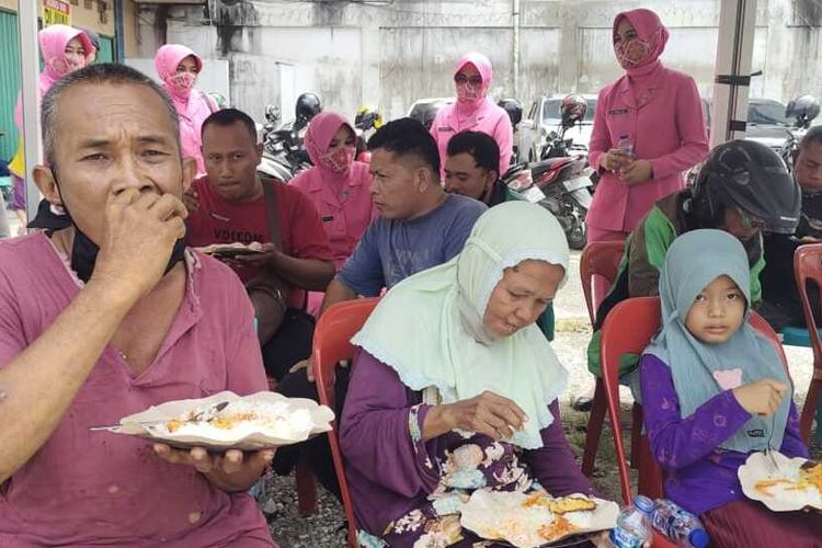 Warga makan siang gratis yang disediakan oleh personel Polsek Payung Sekaki di Jalan Riau, Kota Pekanbaru, Riau, Jumat (11/11/2022).
