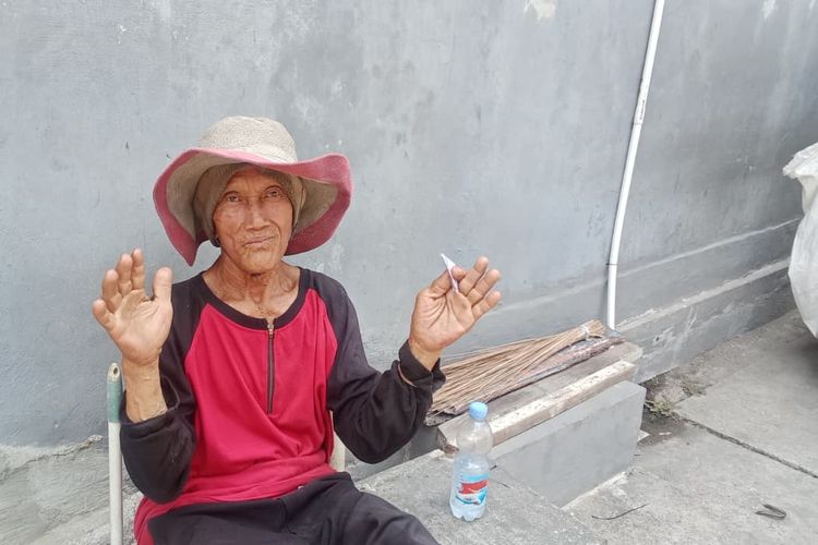Pak Markan, pemungut sampah jalanan yang sedang berpose ke arah kamera saat ia beristirahat di pinggir jalan, Lidah Wetan Gang 1 sambil menunggu adzan sholat Jumat.