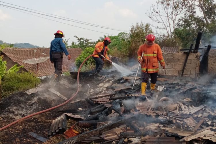 Petugas Damkar Kabupaten Semarang menyemprotkan air untuk pendinginan kandang sapi yang terbakar.