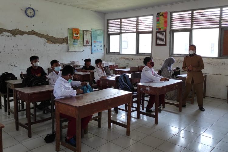 Indriyani (kerudung abu-abu), siswi kelas 6 SDN Margadadi 2 Kabupaten Indramayu yang tidak memakai seragam sekolah saat Kegiatan Pembelajaran Tatap Muka Terbatas (PTMT) dimulai, Senin (16/8/2021). Kabupaten Indramayu Jawa Barat sendiri hari ini menggelar Kegiatan Pembelajaran Tatap Muka Terbatas (PTMT) karena memasuki level 3 dari zona Covid-19.   