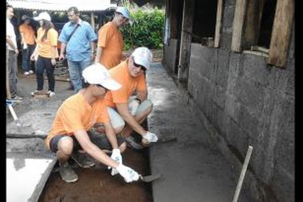 Dua warga asing sedang memplester teras rumah dalam pembangunan rumah tahan gempa di Desa Bedugul, Buleleng, Bali, Kamis (6/3/2014).