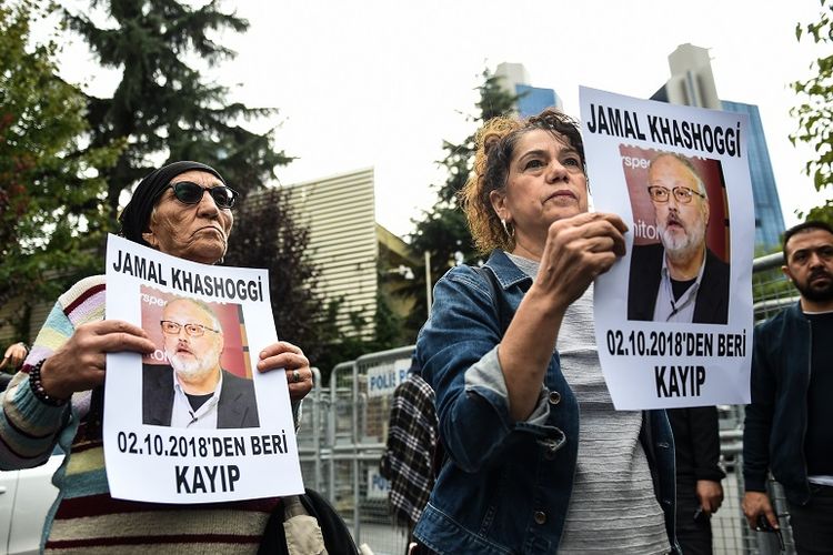 Anggota Asosiasi HAM (IHD) memegang foto Jamal Khashoggi  dalam unjuk rasa di depan kantor Konsulat Arab Saudi di Istanbul, Turki.