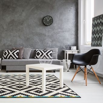 Ilustrasi ruang tamu dengan nuansa hitam dan putih, karpet di ruang tamu. 