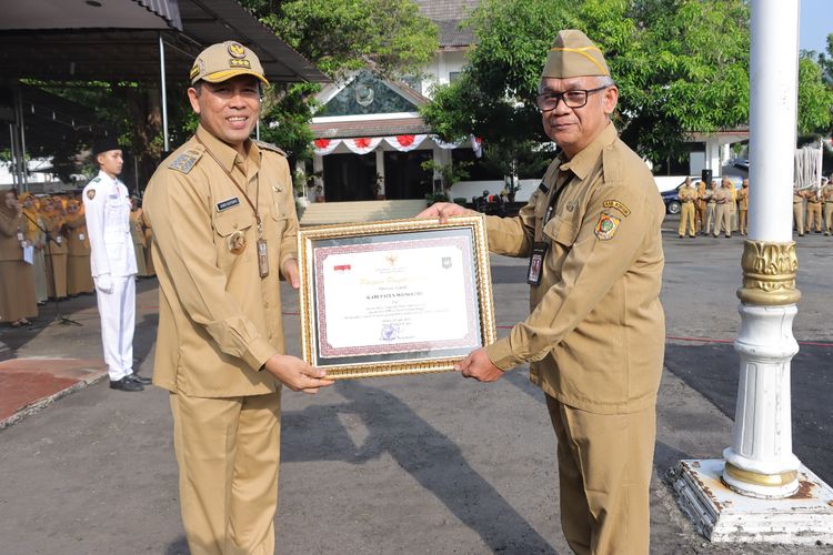 Bupati Wonogiri Joko Sutopo menyerahkan Piagam Penghargaan Prestasi Penyelenggaraan Pemerintah Daerah dengan Skor 3,59 dan Status Kinerja Tinggi Berdasarkan Evaluasi Penyelenggaraan Pemerintah Daerah (EPPD) Tahun 2022 dari Kemendagri kepada Sekda Wonogiri Haryono usai memperingati Hari Pendidikan Nasional dan Hari Otonomi Daerah di halaman Pendopo Pemkab Wonogiri, Selasa (2/5/2023).