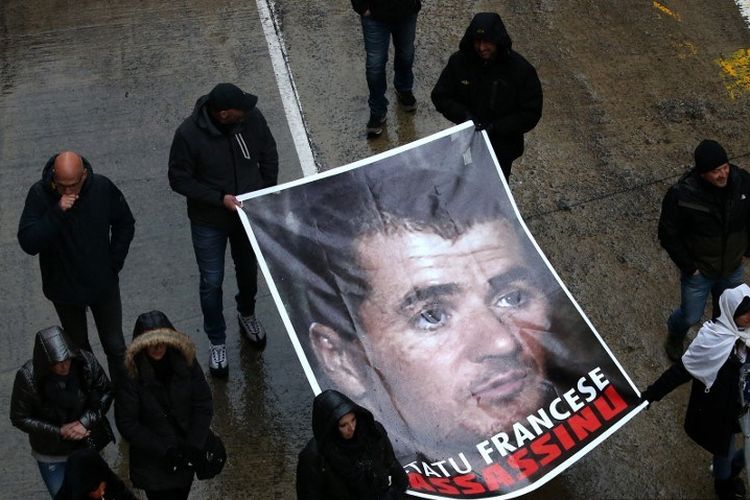 Dalam file foto yang diambil pada 13 Maret 2022 di Bastia, pengunjuk rasa memegang potret Yvan Colonna selama rapat umum untuk memberi penghormatan kepada aktivis pro-kemerdekaan setelah dia diserang di penjara Arles. 