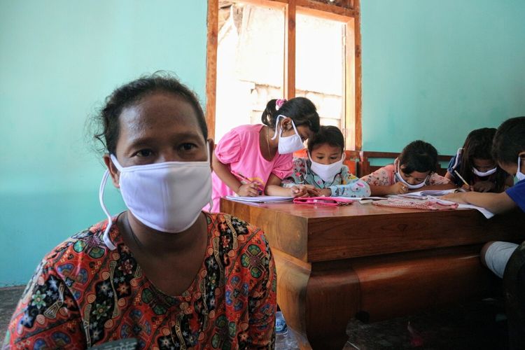 Karlik (41), saat menemani anaknya mengikuti pembelajaran daring di salah satu rumah yang menyediakan akses internet melalui WiFi, di Desa Marmoyo, Kecamatan Kabuh, Kabupaten Jombang, Jawa Timur, Rabu (22/72020).