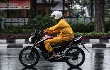 Pengendara sepeda motor mengenakan jas hujan saat terjadi hujan di Jalan Katedral, Sawah Besar, Jakarta Pusat, Minggu (22/12/2019). Badan Meteorologi, Klimatologi, dan Geofisika (BMKG) memberikan informasi dini cuaca ektrem yang akan melanda sejumlah wilayah di Indonesia pada hari Minggu (22/12/2019), dan Senin (23/12/2019).